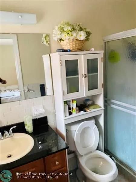 bathroom featuring tasteful backsplash, vanity, and toilet