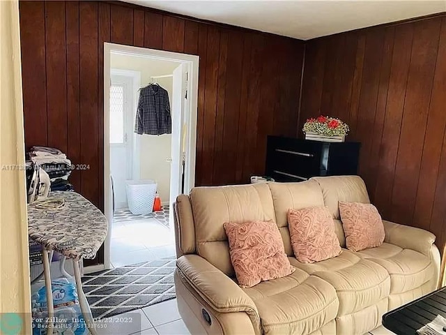 living room with wood walls and light tile patterned floors