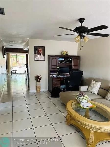 tiled living room featuring ceiling fan