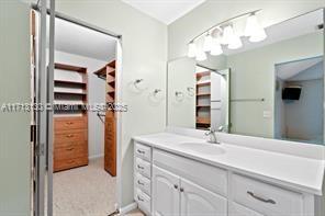 kitchen with white cabinets, white fridge, light tile patterned floors, hanging light fixtures, and a chandelier