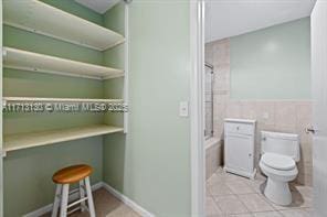 bathroom with tile walls, tile patterned floors, and toilet