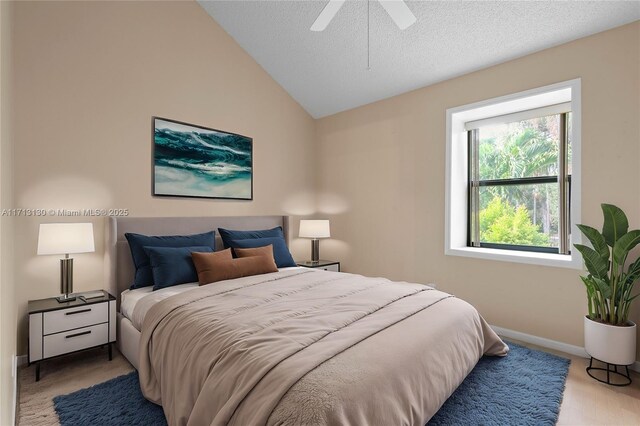 carpeted bedroom with vaulted ceiling, ceiling fan, and a textured ceiling