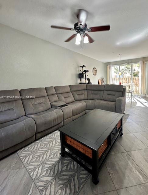 tiled living room featuring ceiling fan