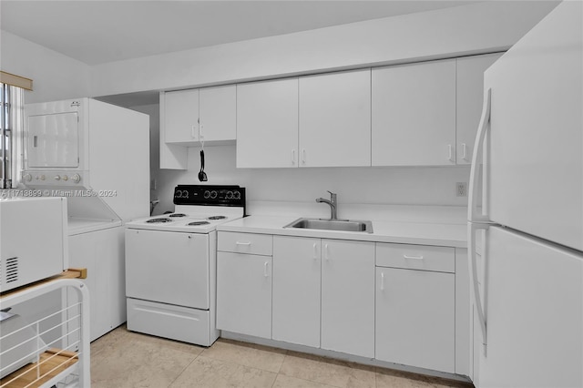 kitchen with white appliances, sink, light tile patterned floors, stacked washer / dryer, and white cabinets