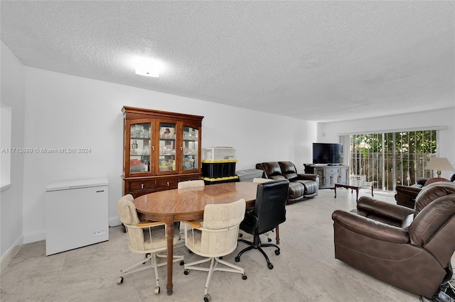 dining space featuring a textured ceiling