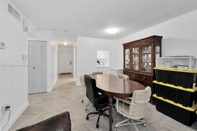 dining area featuring a textured ceiling