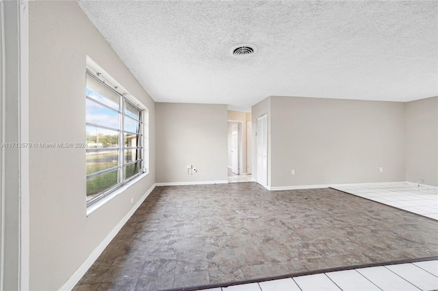 unfurnished room featuring a textured ceiling