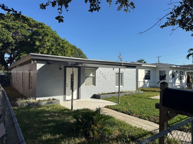 back of property featuring a patio area and a lawn