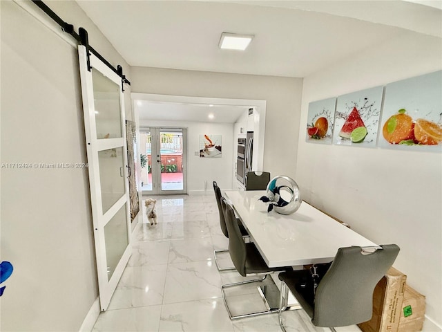 dining area featuring a barn door and french doors