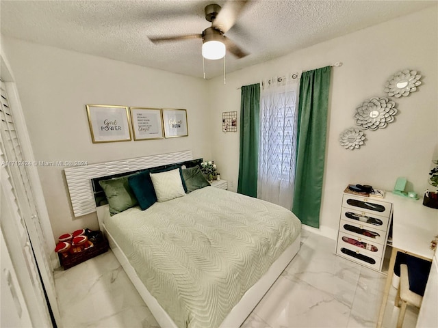 bedroom featuring ceiling fan and a textured ceiling