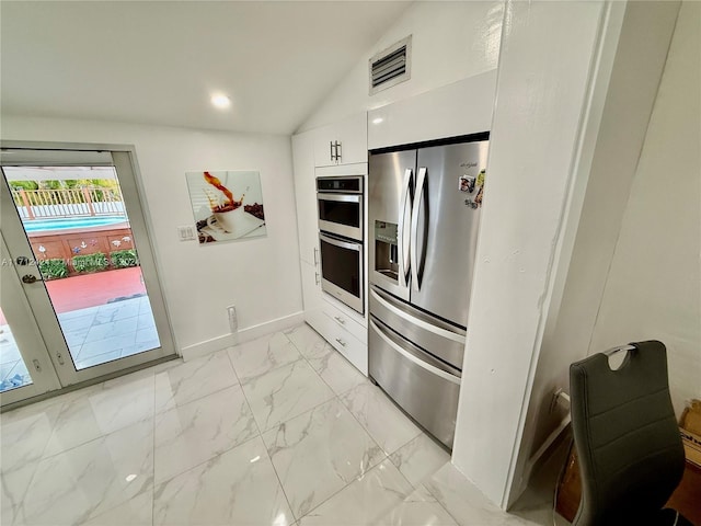 kitchen with white cabinets, stainless steel appliances, and lofted ceiling