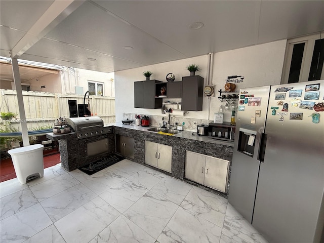 kitchen featuring sink and stainless steel refrigerator with ice dispenser