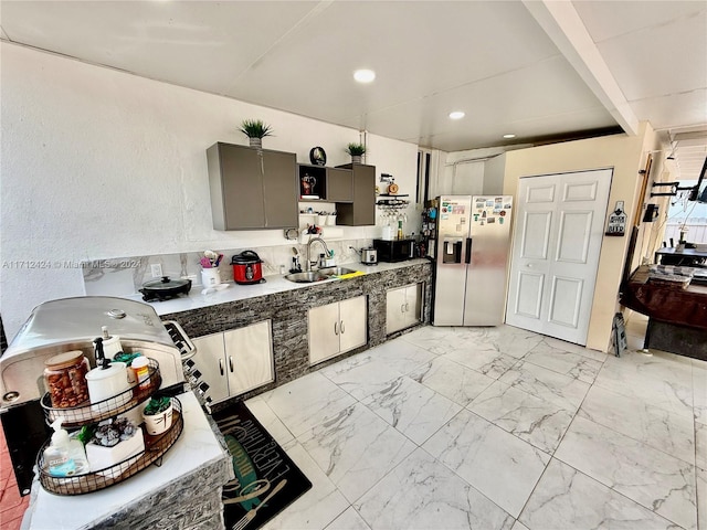 kitchen featuring gray cabinets, sink, and stainless steel refrigerator with ice dispenser