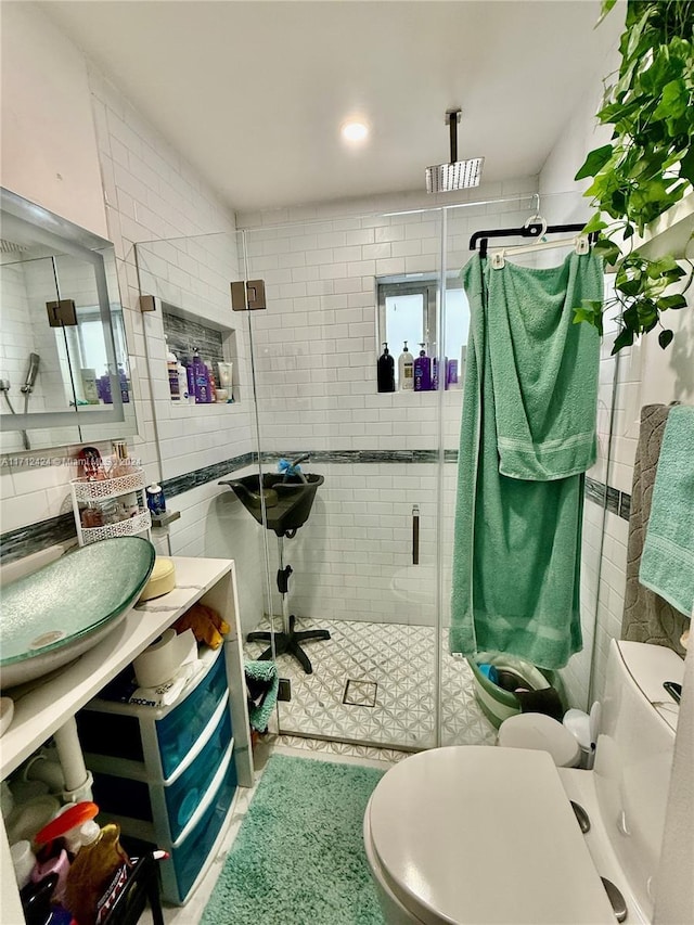 bathroom featuring toilet, walk in shower, and tile walls