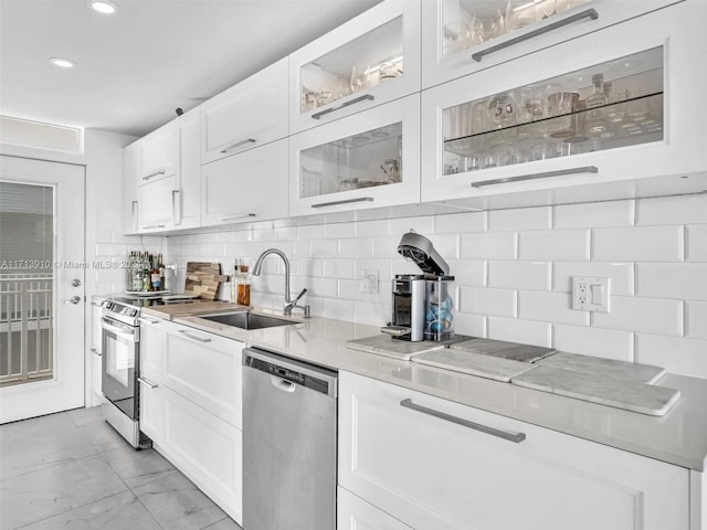 kitchen featuring decorative backsplash, appliances with stainless steel finishes, white cabinetry, and sink