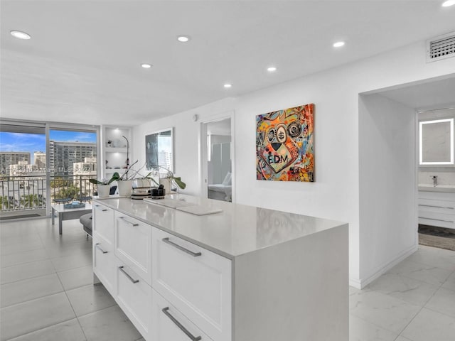 kitchen featuring expansive windows, white cabinets, and a kitchen island