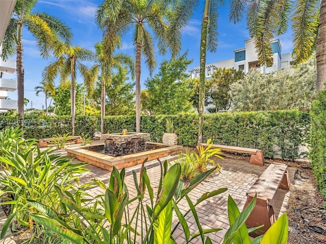 view of property's community with a patio and an outdoor fire pit