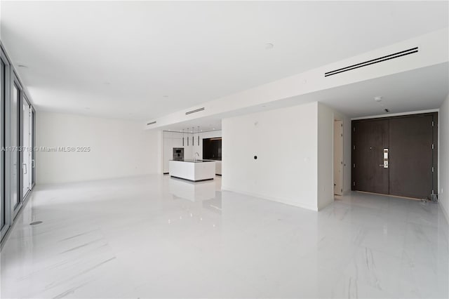 empty room featuring marble finish floor, visible vents, and a sink