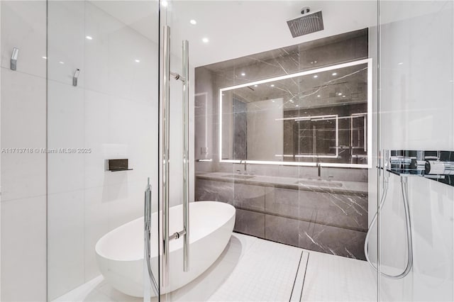 full bath with vanity, a freestanding tub, a shower with door, and tile walls