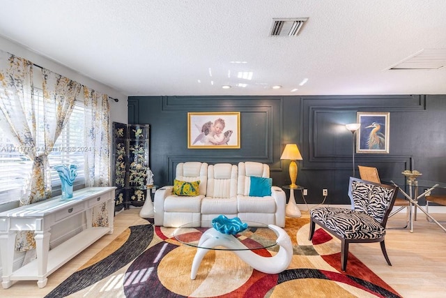 living room featuring a textured ceiling and light hardwood / wood-style floors