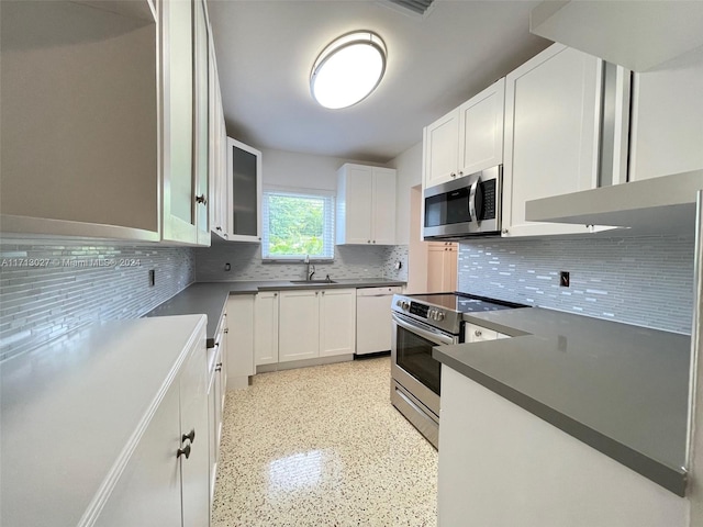 kitchen featuring appliances with stainless steel finishes, backsplash, white cabinetry, and sink