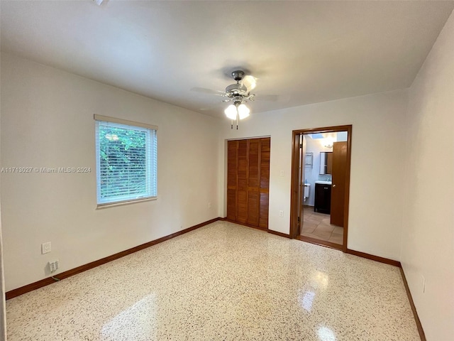 unfurnished bedroom with connected bathroom, a closet, and ceiling fan