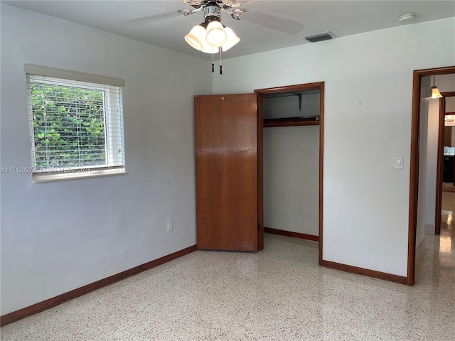 unfurnished bedroom with ceiling fan and a closet