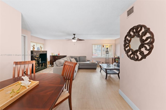 dining room featuring ceiling fan, light hardwood / wood-style floors, and a textured ceiling