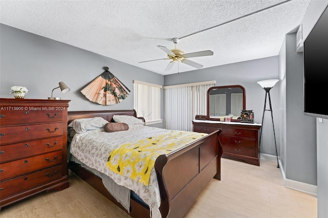 bedroom with ceiling fan and a textured ceiling