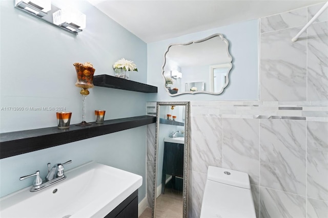 bathroom featuring vanity, toilet, and tile walls