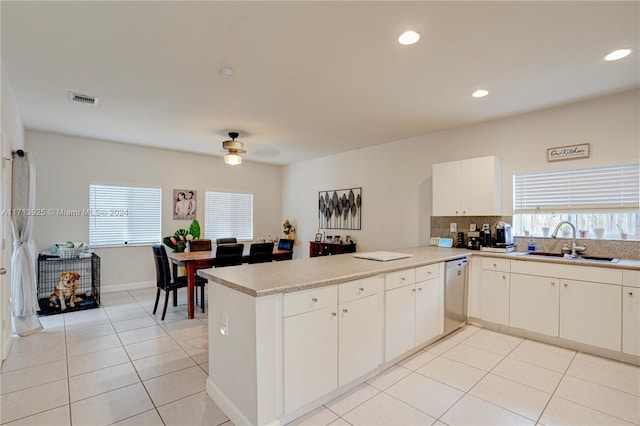 kitchen with ceiling fan, dishwasher, sink, kitchen peninsula, and white cabinets