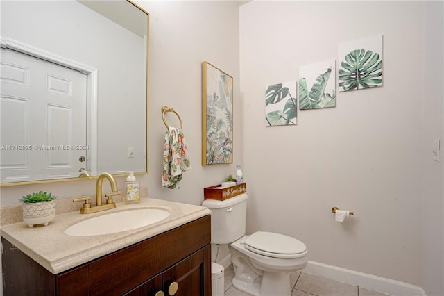 bathroom with toilet, vanity, and tile patterned floors