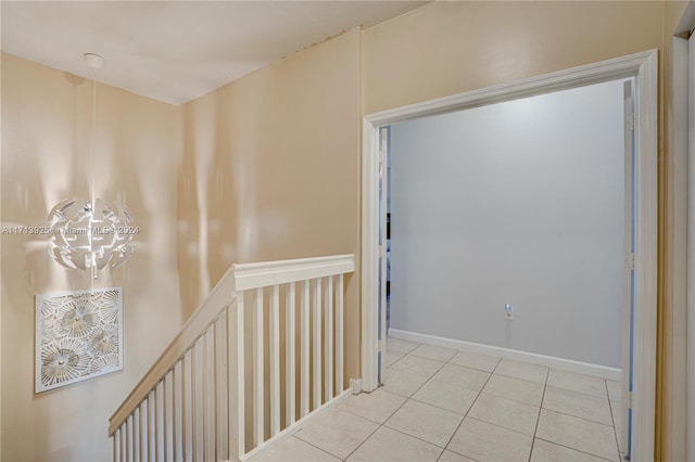 hall featuring light tile patterned floors and an inviting chandelier