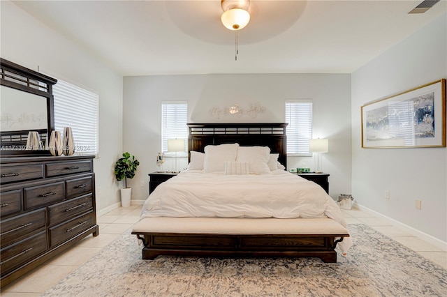 bedroom featuring multiple windows, light tile patterned floors, and ceiling fan