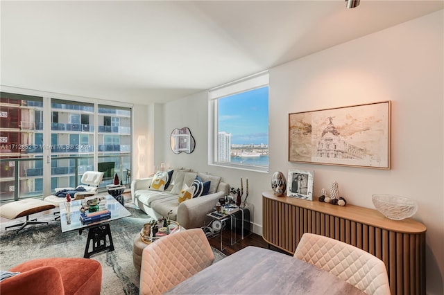 living room featuring a water view, a wall of windows, and dark wood-type flooring