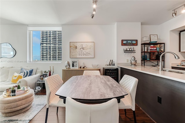 dining room featuring sink, rail lighting, and hardwood / wood-style floors