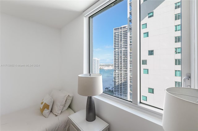 bedroom featuring a water view and multiple windows