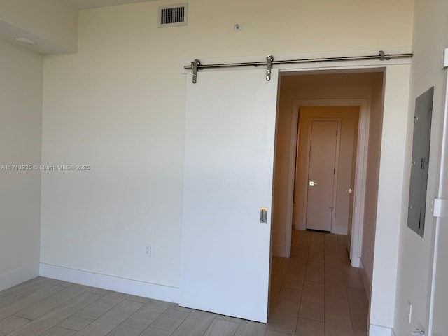 unfurnished room with wood-type flooring and a barn door