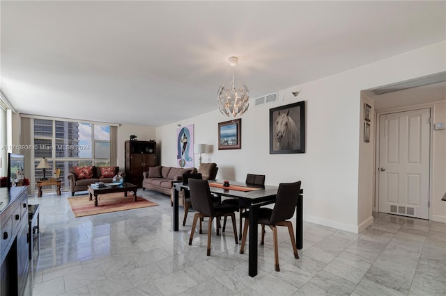 dining space featuring a notable chandelier and a wall of windows