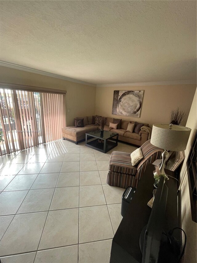 living room featuring light tile patterned flooring, ornamental molding, and a textured ceiling