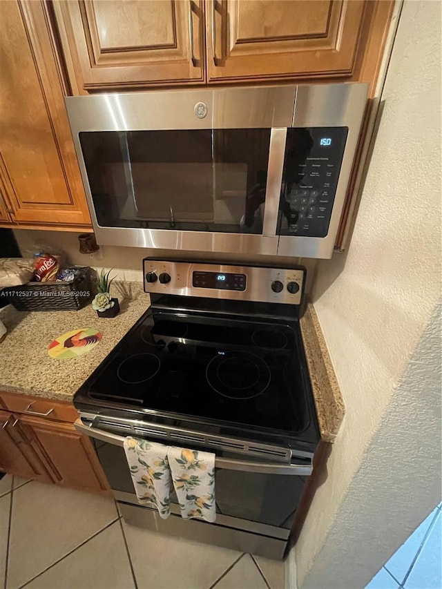 kitchen with light stone counters and appliances with stainless steel finishes