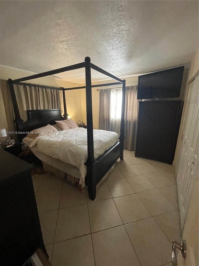 tiled bedroom with a textured ceiling