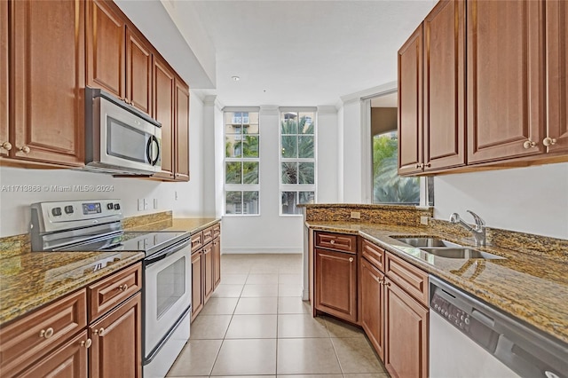 kitchen featuring light stone countertops, sink, and appliances with stainless steel finishes