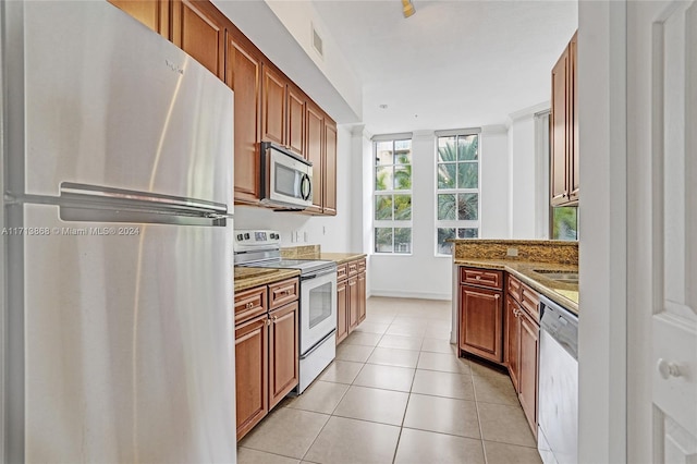 kitchen featuring light stone countertops, light tile patterned floors, and appliances with stainless steel finishes