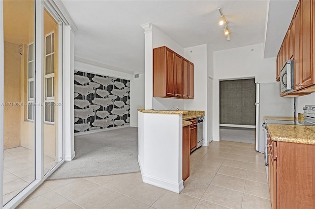 kitchen featuring light tile patterned flooring, light stone counters, and appliances with stainless steel finishes