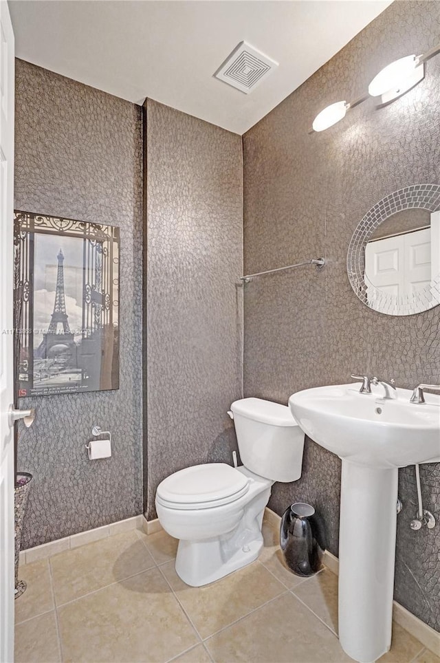 bathroom featuring tile patterned flooring, toilet, and sink