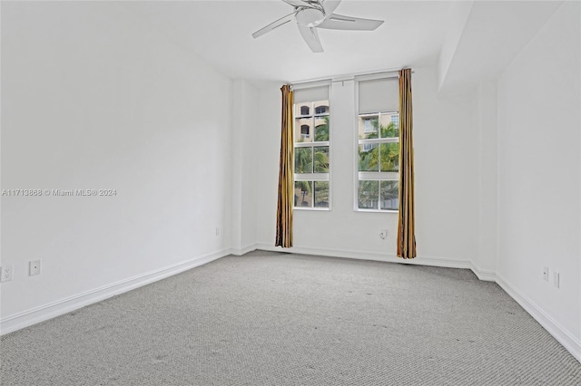 carpeted spare room with ceiling fan