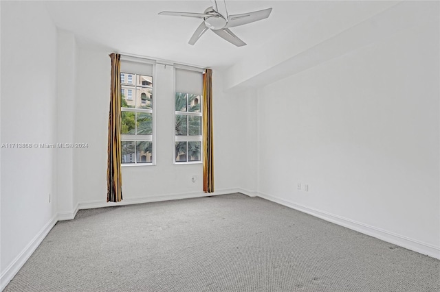 carpeted spare room with ceiling fan