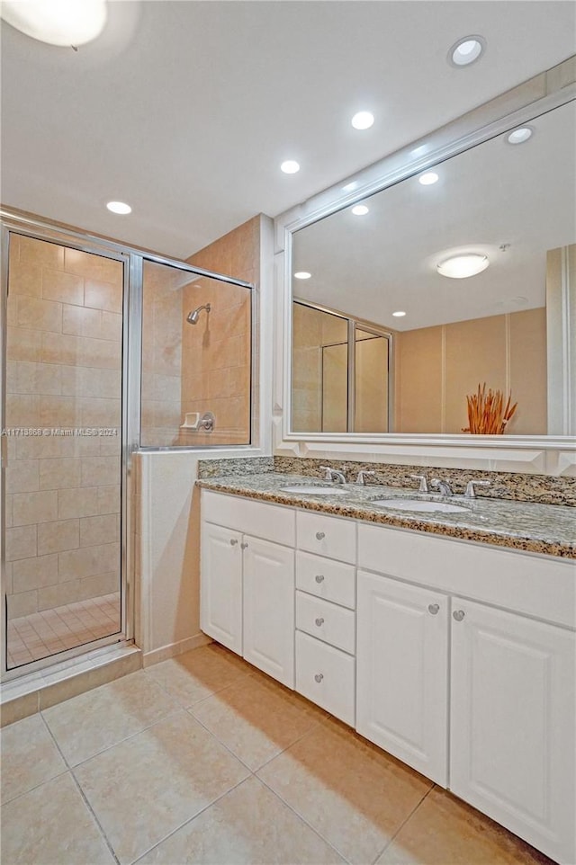 bathroom with tile patterned floors, vanity, and a shower with door