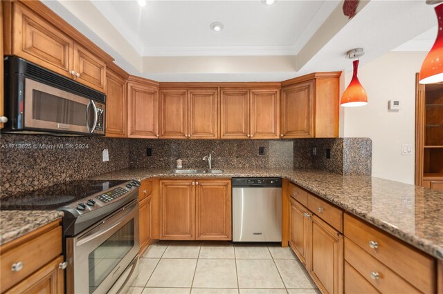 kitchen featuring appliances with stainless steel finishes, tasteful backsplash, sink, stone countertops, and decorative light fixtures